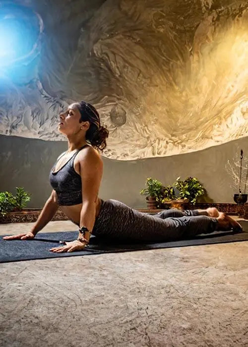 Boutique yoga en ligne - Yogini réalisant la posture du Cobra dans une salle zen - Achamana