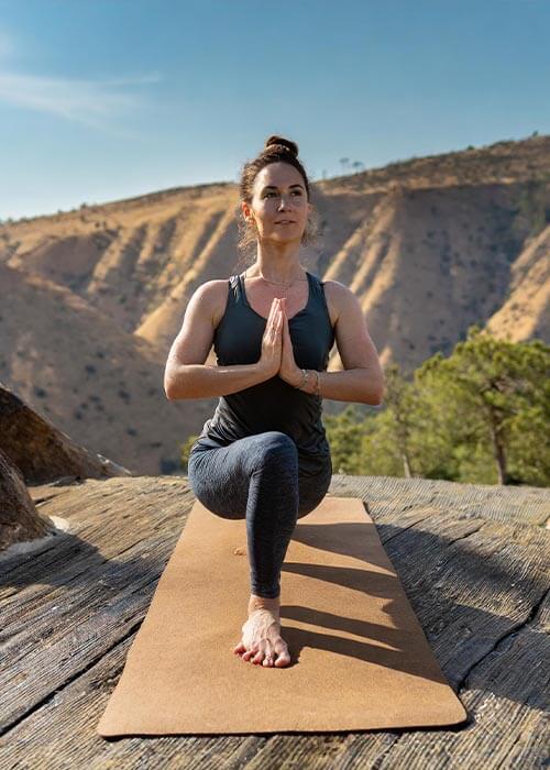 Tapis de yoga de voyage fin et pliable - Yogini pratique un yoga nomade en pleine montagne | Achamana