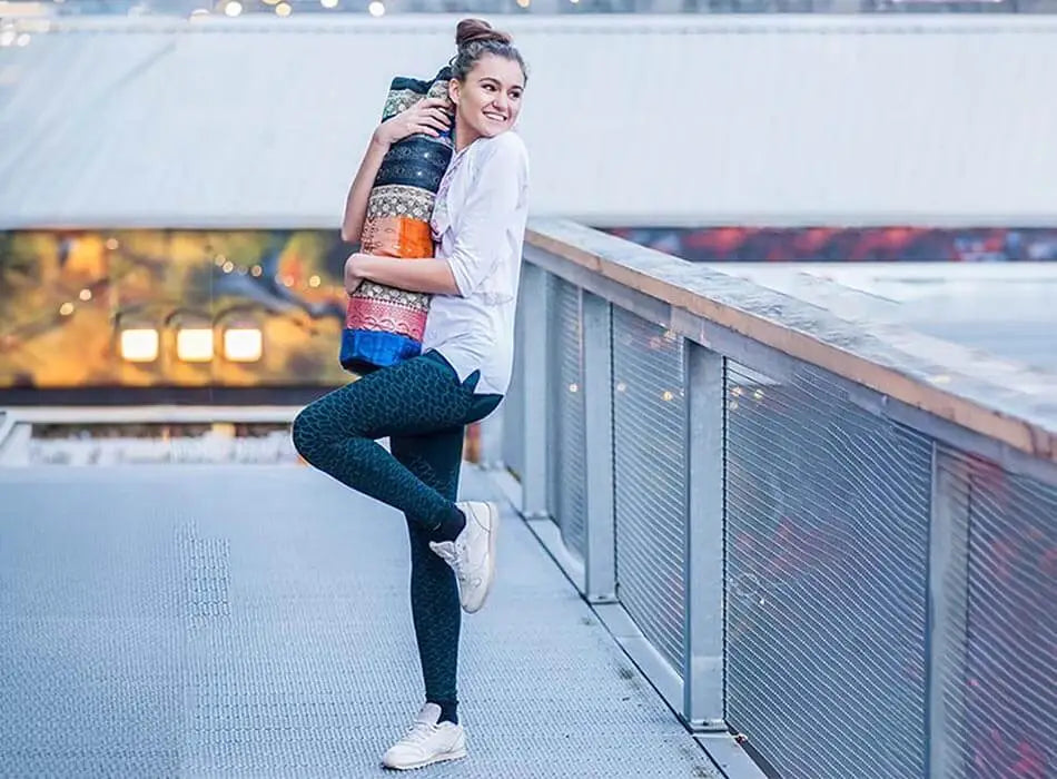 Sac pour tapis de yoga - Yogini sur une terrasse qui enlace son sac de yoga | Achamana