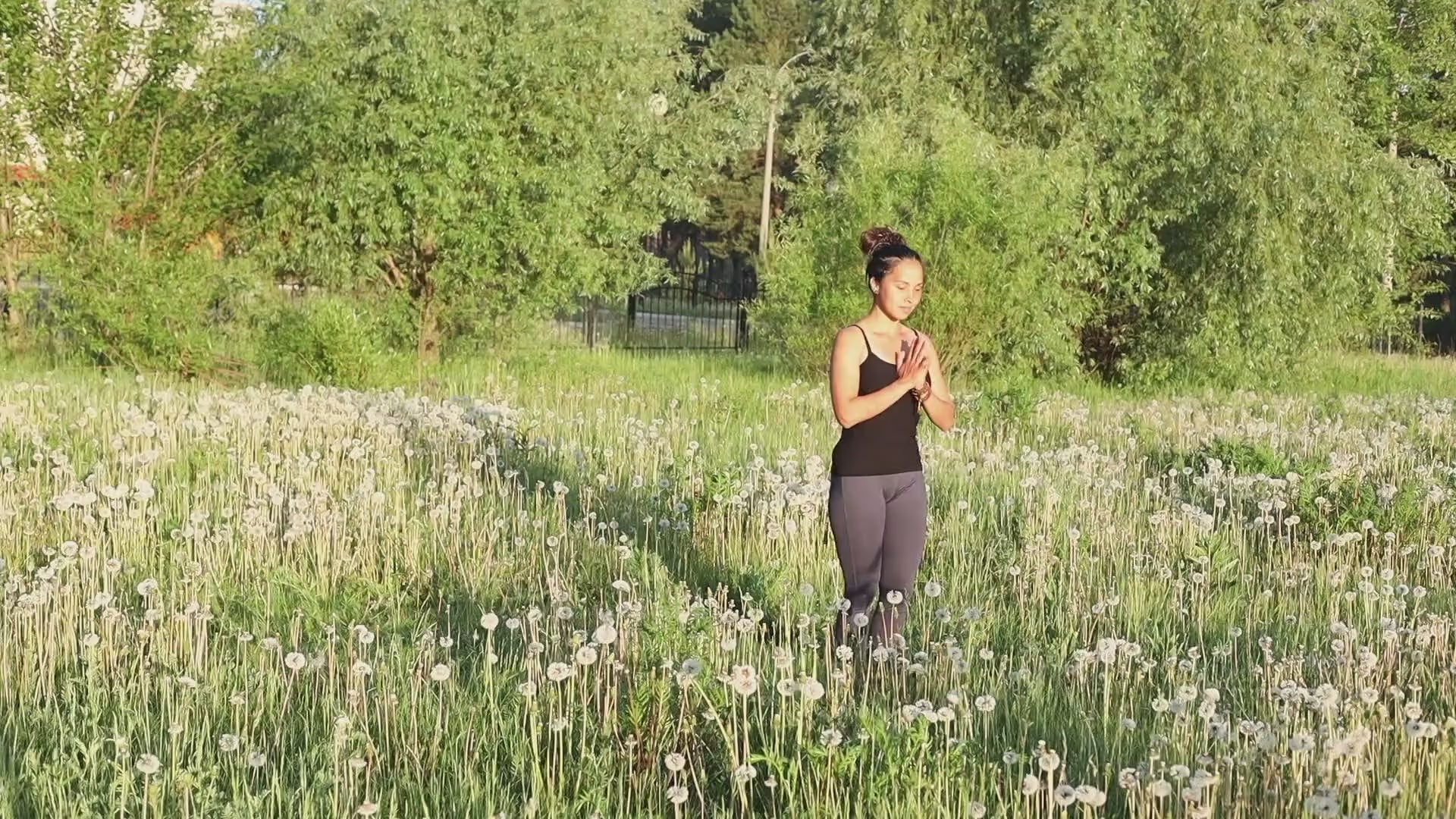 Une yogini portant les vêtements de yoga de la marque Achamana pratique dans un près  | Achamana